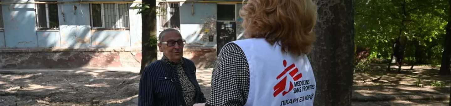 Eine unserer Mitarbeitenden spricht mit einer älteren Frau