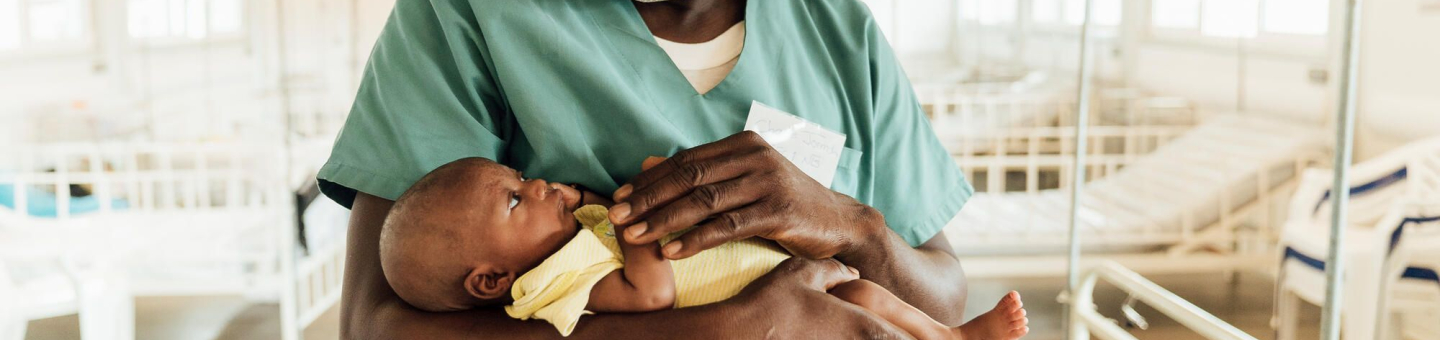 Ein Arzt hält ein Baby in den Armen