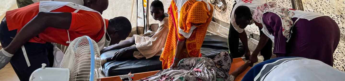 Mitarbeitende behandeln Kriegsverletzte auf Baren