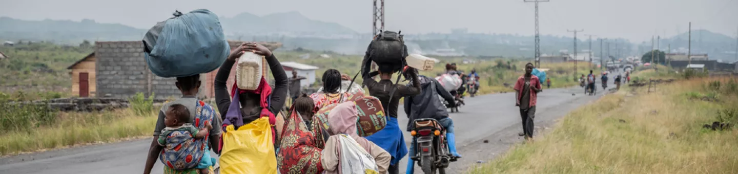 Sehr viele Menschen sind m Osten der Demokratischen Republik Kongo auf der Flucht D. R. Kongo: Menschen laufen an Straßenrand mit Gepäck beladen