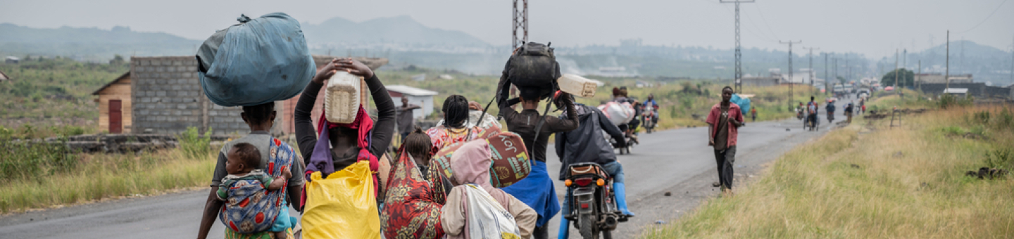Sehr viele Menschen sind m Osten der Demokratischen Republik Kongo auf der Flucht D. R. Kongo: Menschen laufen an Straßenrand mit Gepäck beladen