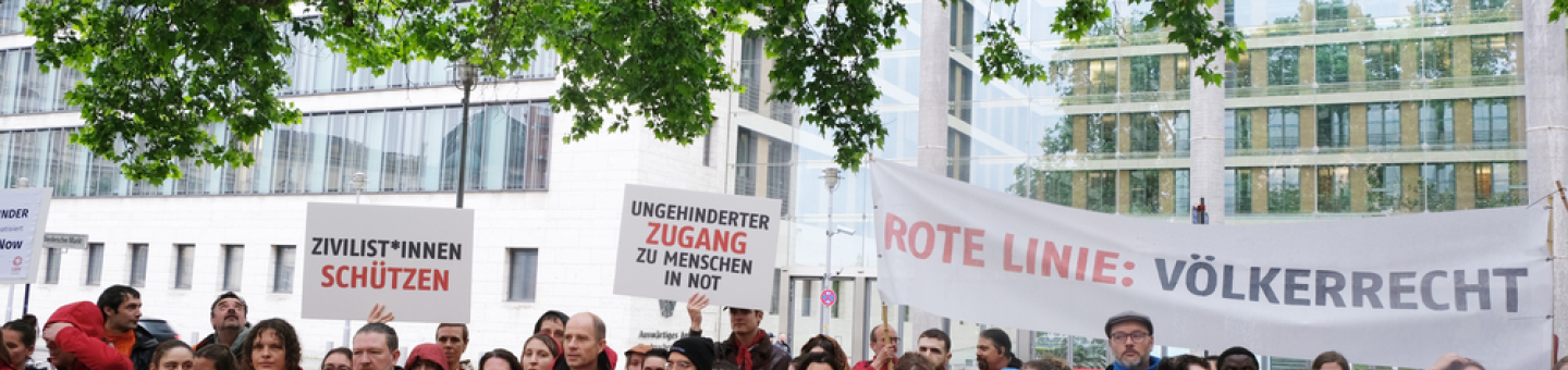 Hilfsorganisationen, darunter Ärzte ohne Grenzen, demonstrieren vor dem Auswärtigen Amt in Berlin gegen die Instrumentalisierung humanitärer Hilfe im Gazastreifen. Menschen mit Plakaten demonstrieren vor Auswärtigem Amt
