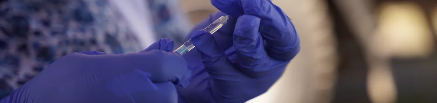 Masernimpfung wird aus Ampulle von Mitarbeiter entnommen.