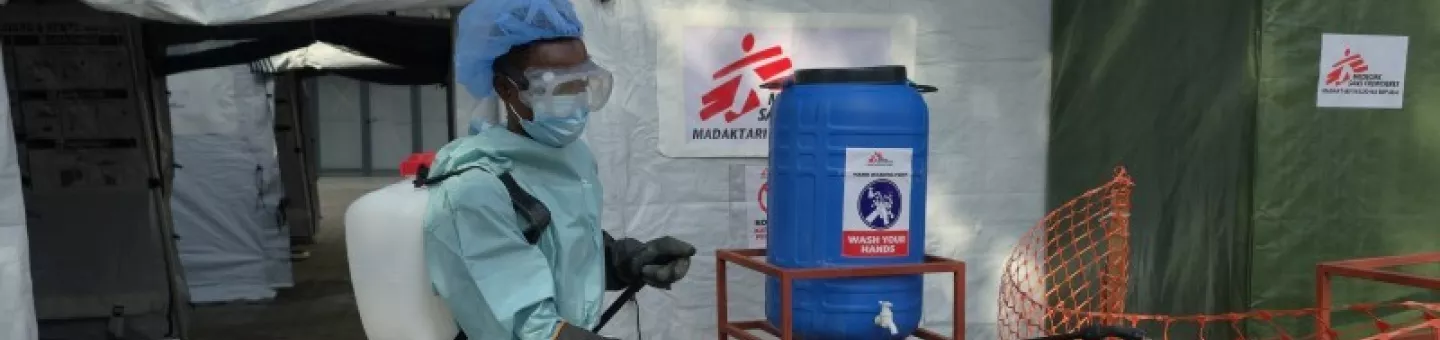 Mitarbeiter in Schutzkleidung vor Behandlungszelt