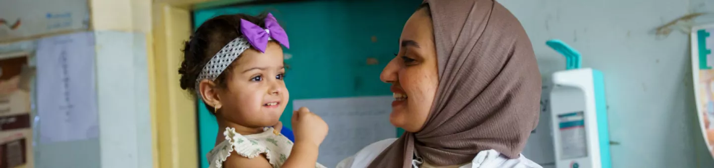 EIne Frau hat ein Kind auf dem Arm