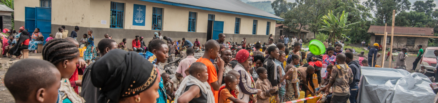 Viele Menschen, die aufgrund des Vulkanausbruchs in Goma flüchten mussten, stehen in einer Reihe, um sich Trinkwasser abzuholen.