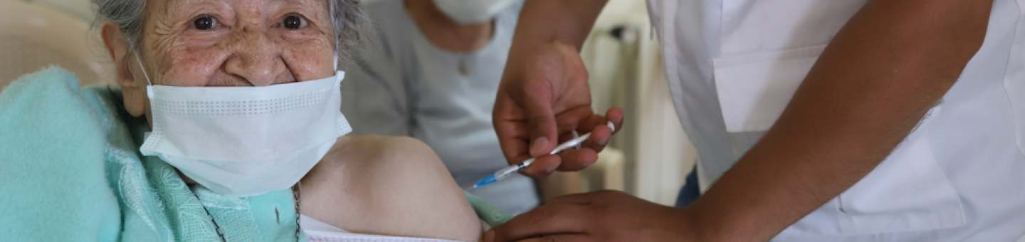 Ein Mitarbeiter von Ärzte ohne Grenzen impft die Bewohnerin eines Altersheims im Libanon gegen Covid-19. Covid-19-Impfung Libanon Impfstoffproduktion globaler Süden