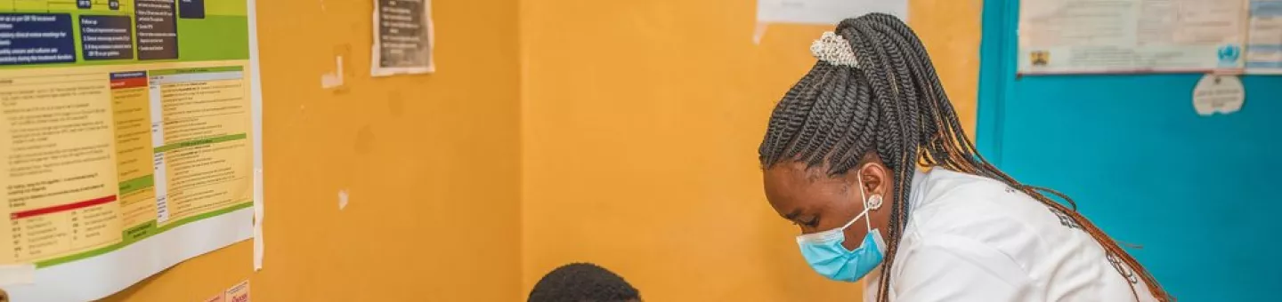 Eine Pflegekraft misst bei einem Patienten den Blutdruck