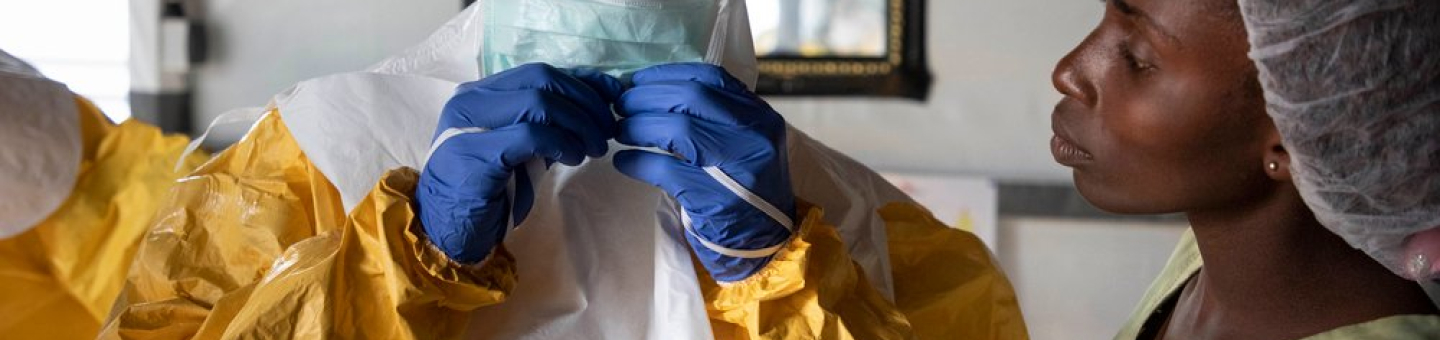 Ein Mitarbeiter zieht sich die Schutzausrüstung an, bevor er das Ebola-Transitzentrum in Bunia, Demokratische Republik Kongo betritt. Mitarbeiter in Schutzausrüstung vor Ebola-Transitzentrum