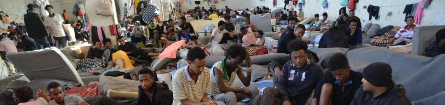 Geflüchtete und Migranten sitzen dicht gedrängt in einem Internierungslager 