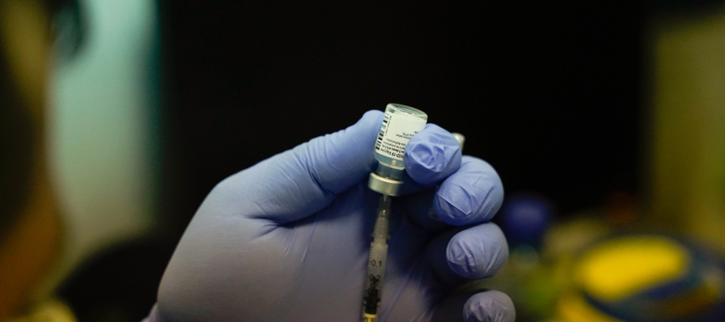 Impfstoff wird aus einer Ampulle in einer Spritze aufgezogen.