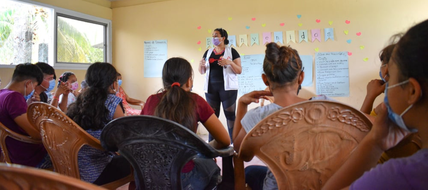 Eine Mitarbeiterin im Gespräch mit Jugendlichen in Honduras.