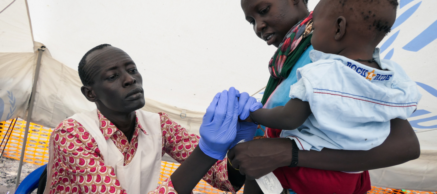 Eine Krankenschwester testet ein Kind auf Malaria.