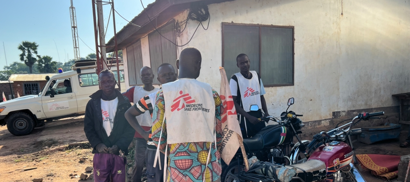 Fünf Männer in Ärzte ohne Grenzen Shirts neben Motorrädern