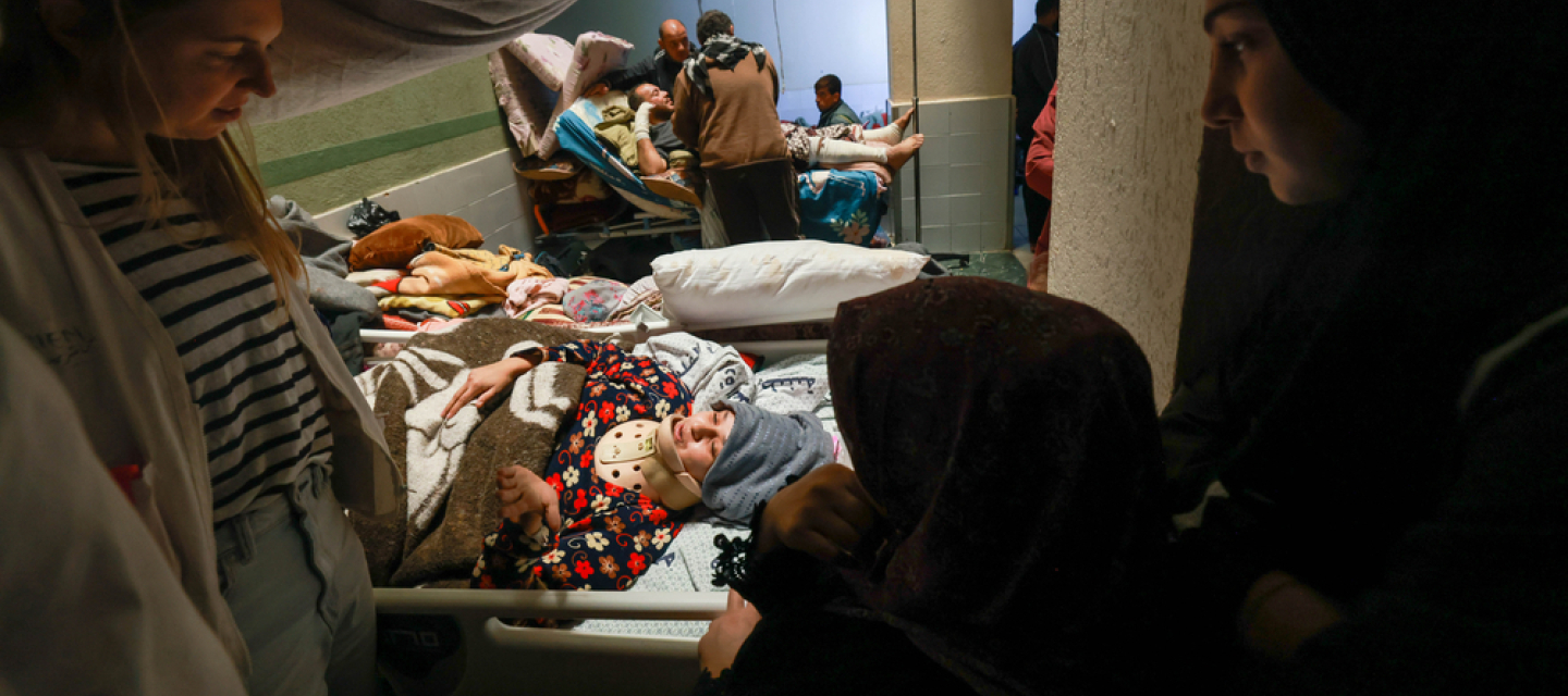 Behandelnde und Angehörige am Bett einer Patientin.