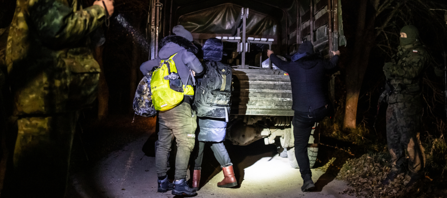 Militärfahrzeug und Geflüchtete an der Grenze zu Polen