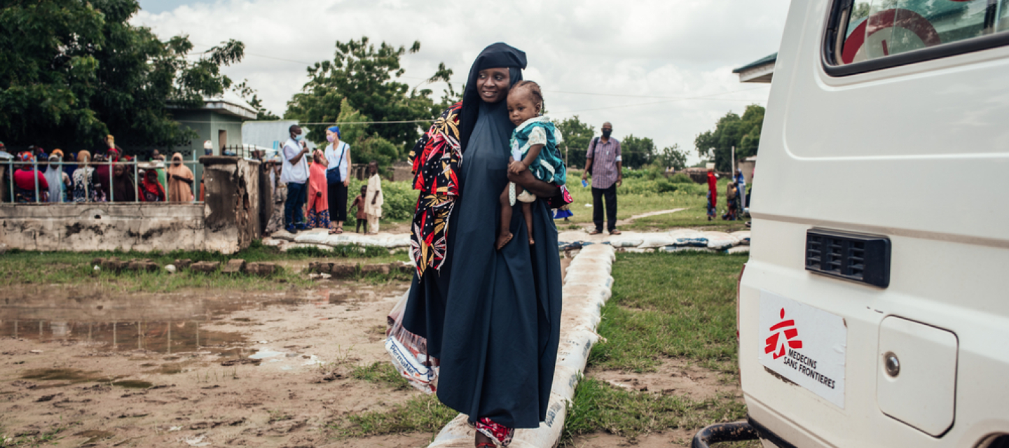 Wir behandeln Mangelernährung in Nigeria. Frau trägt Töchter auf Arm