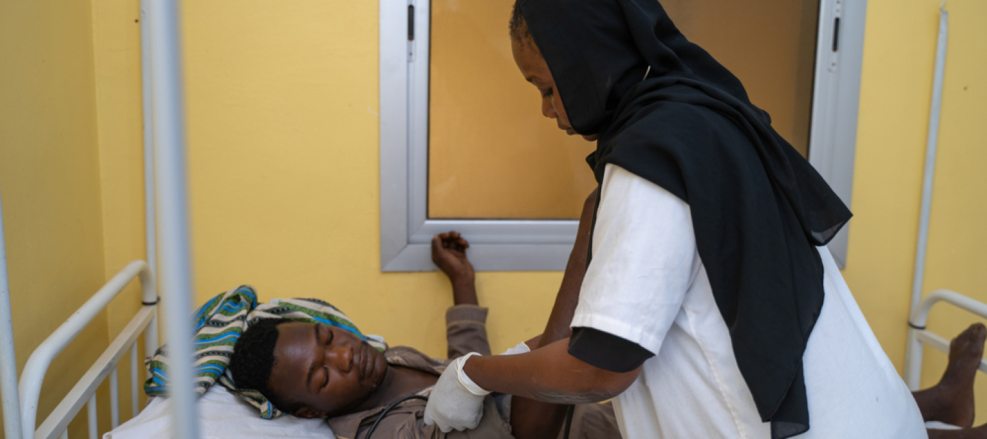 Krankenschwester mit Stethoskop an Patientenbett