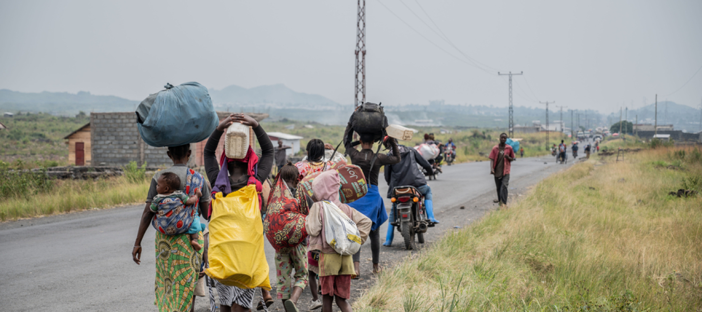 Sehr viele Menschen sind m Osten der Demokratischen Republik Kongo auf der Flucht D. R. Kongo: Menschen laufen an Straßenrand mit Gepäck beladen