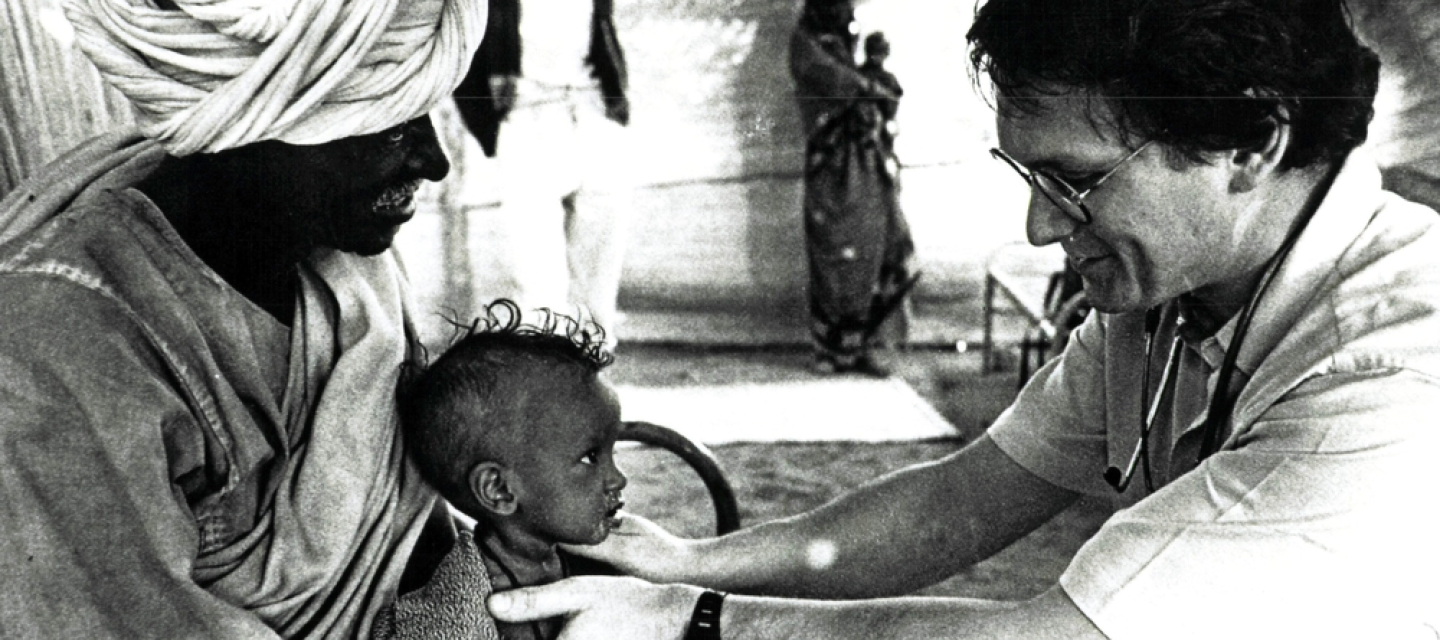 Dr. Rony Brauman behandelt ein Kind Schwarz-weiß-Foto von Arzt der Kind behandelt
