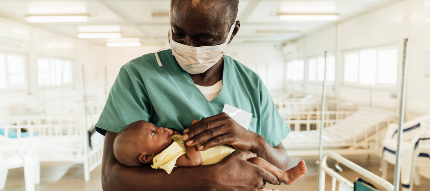 In der Kinderklinik in Kenema behandeln wir seit März 2019 Kinder unter 5 Jahren Charles Jormoh mit Kind auf dem Arm