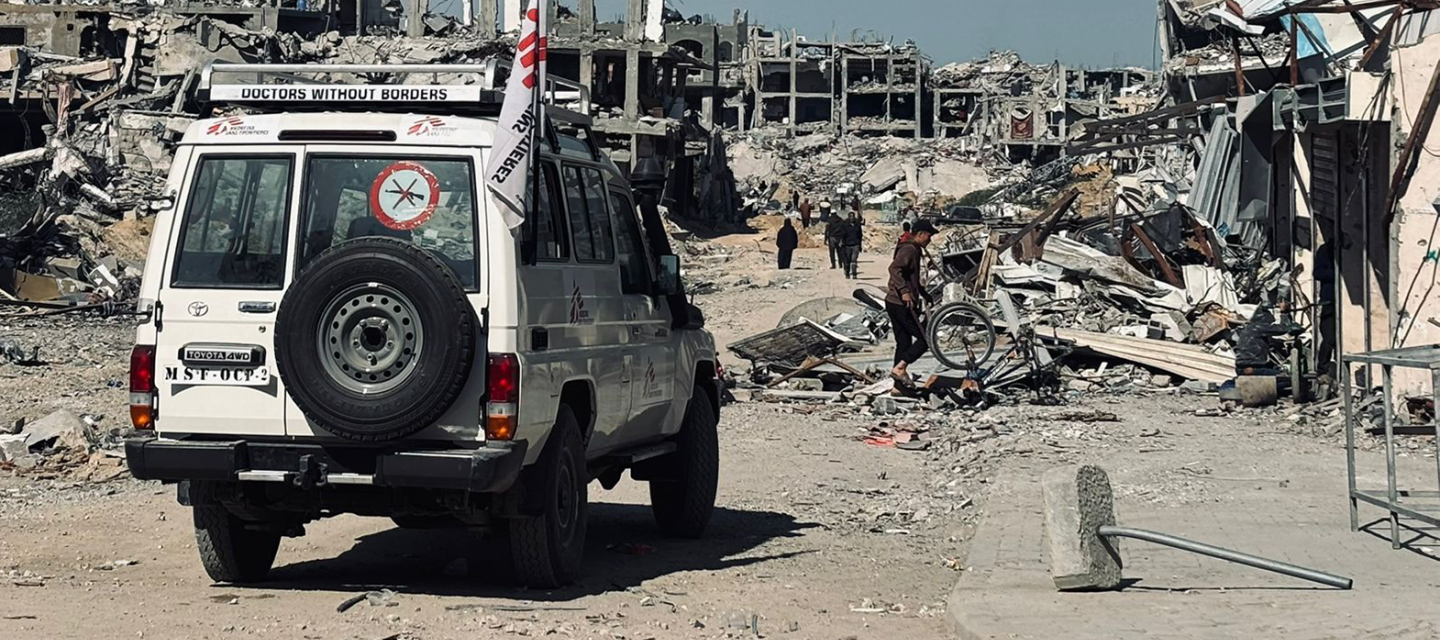 Ein Geländewagen mit dem Logo von Ärzte ohne Grenzen vor zerstörten Gebäuden in Dschabaliya.