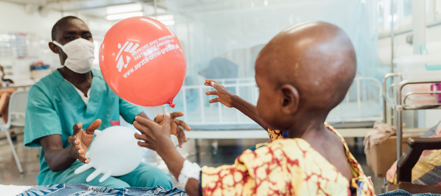 Pfleger bringt kleinen Patientin einen Luftballon