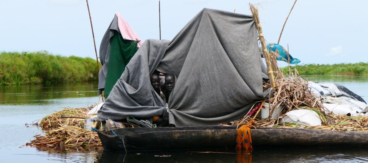 Ein selbst gebautes Floß mit einem Zelt darauf treibt auf dem Wasser