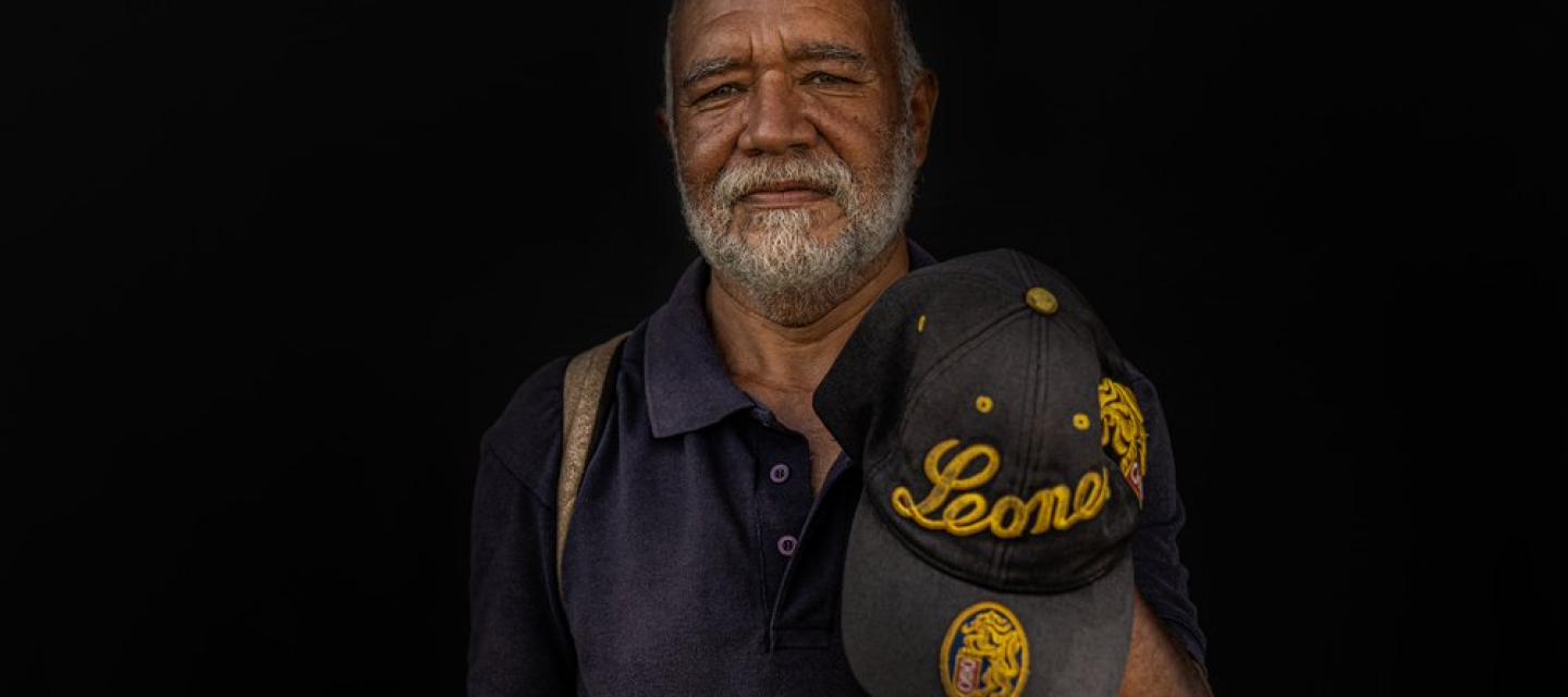 Ein Venezolaner mit einer Baseballmütze in der Hand
