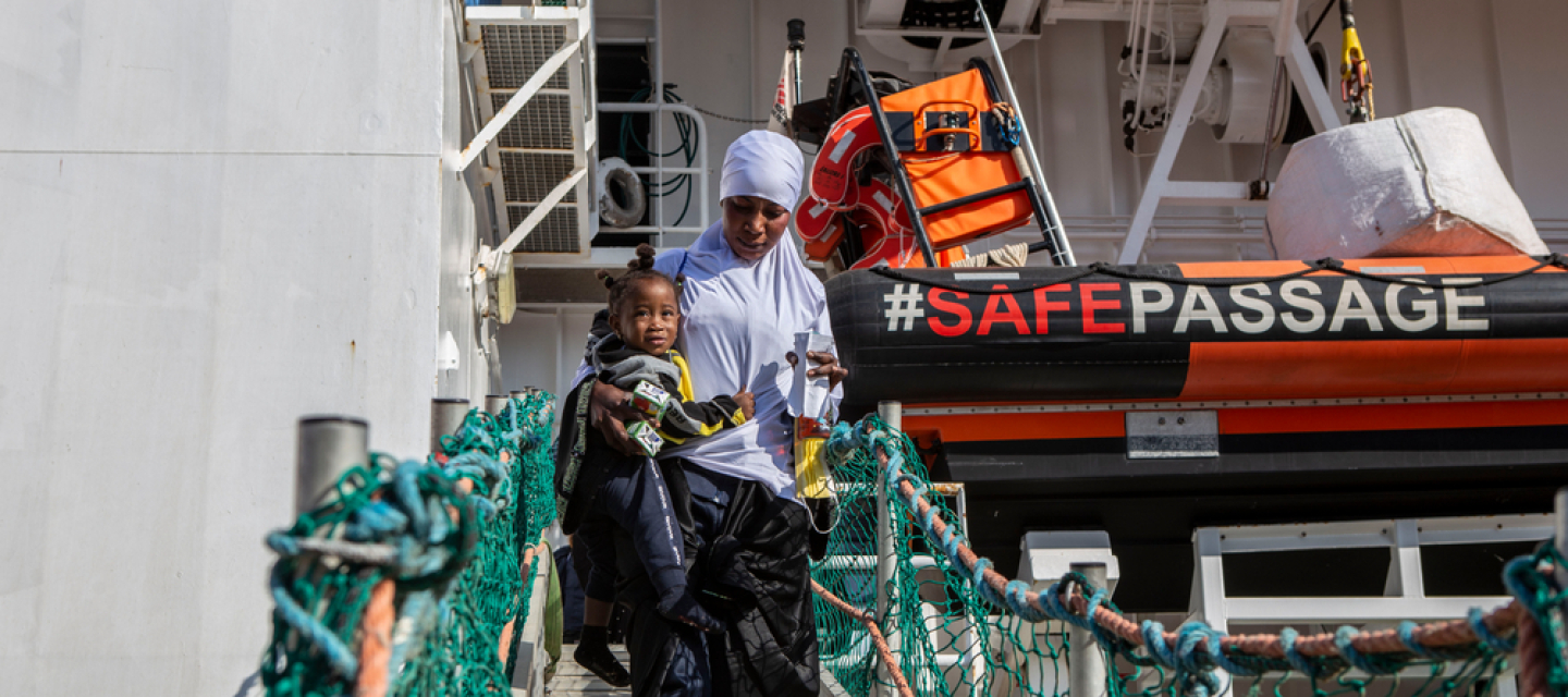 Aus Seenot gerettete Mutter und Kind gehen von Bord der Geo Barents