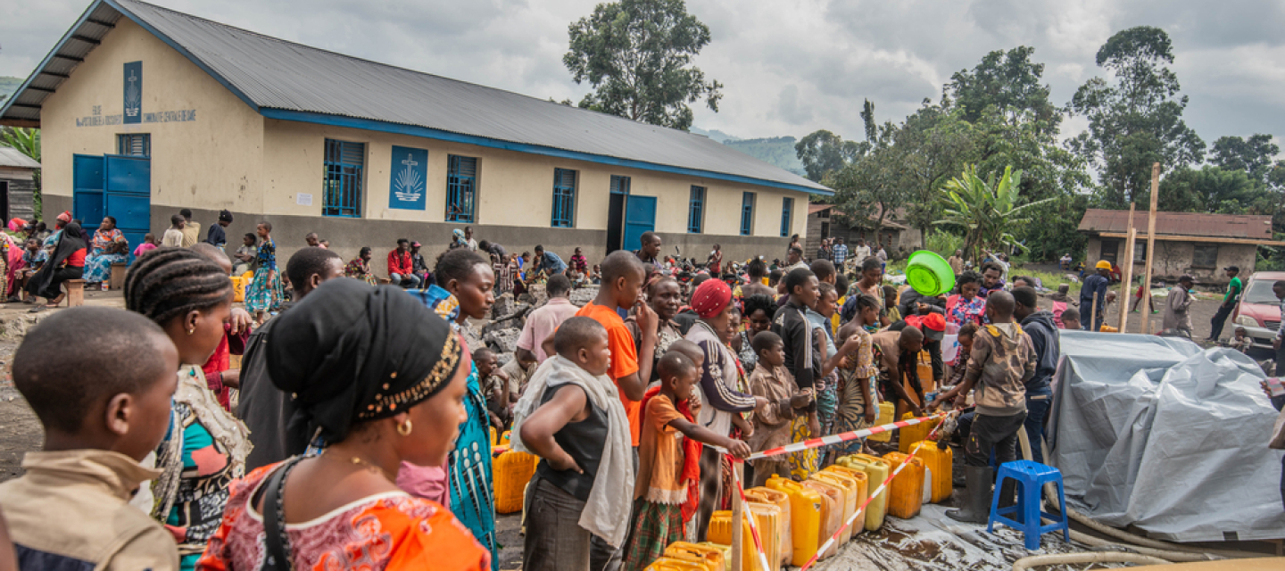 Viele Menschen, die aufgrund des Vulkanausbruchs in Goma flüchten mussten, stehen in einer Reihe, um sich Trinkwasser abzuholen. 