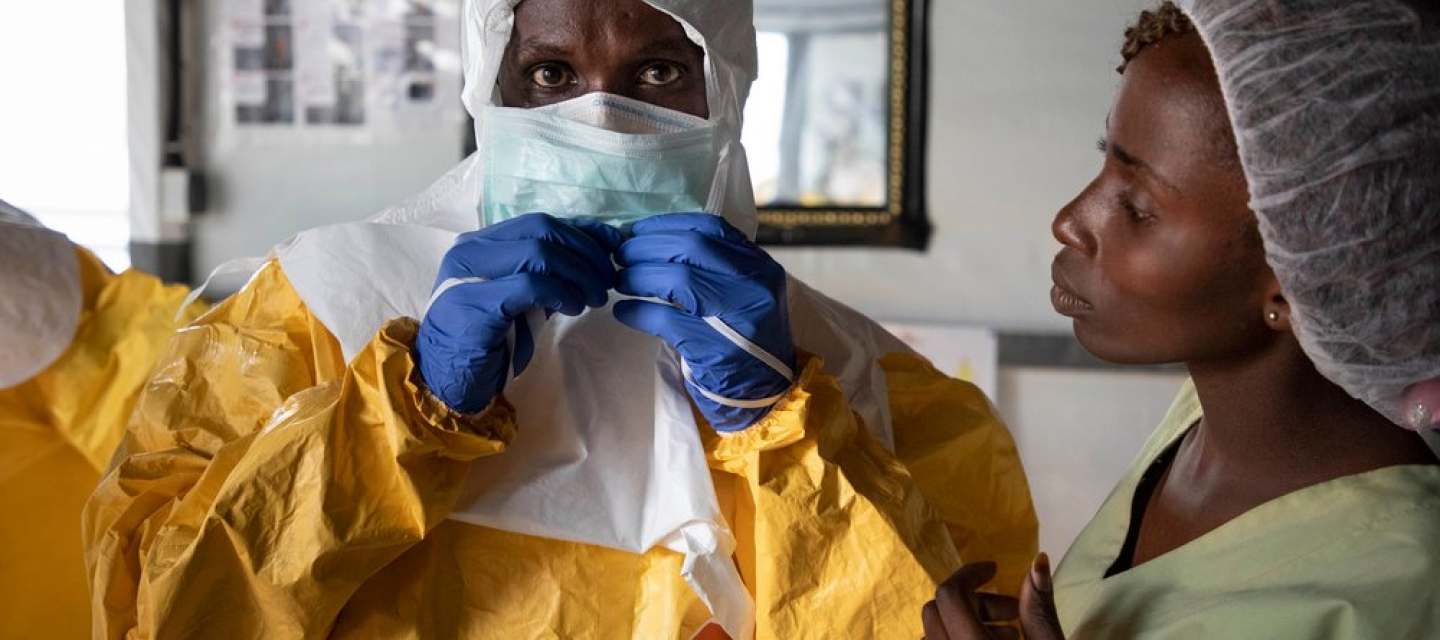 Mitarbeiter in Schutzausrüstung vor Ebola-Transitzentrum