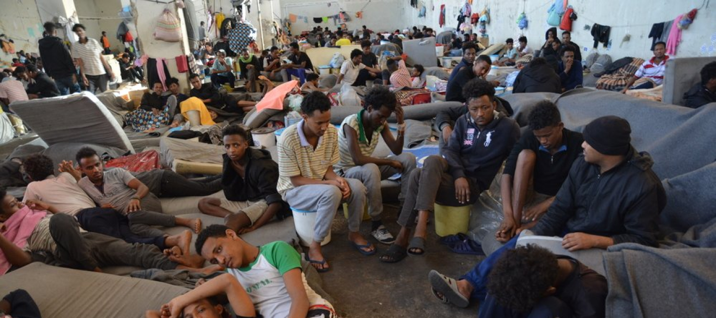 Geflüchtete und Migranten sitzen dicht gedrängt in einem Internierungslager 