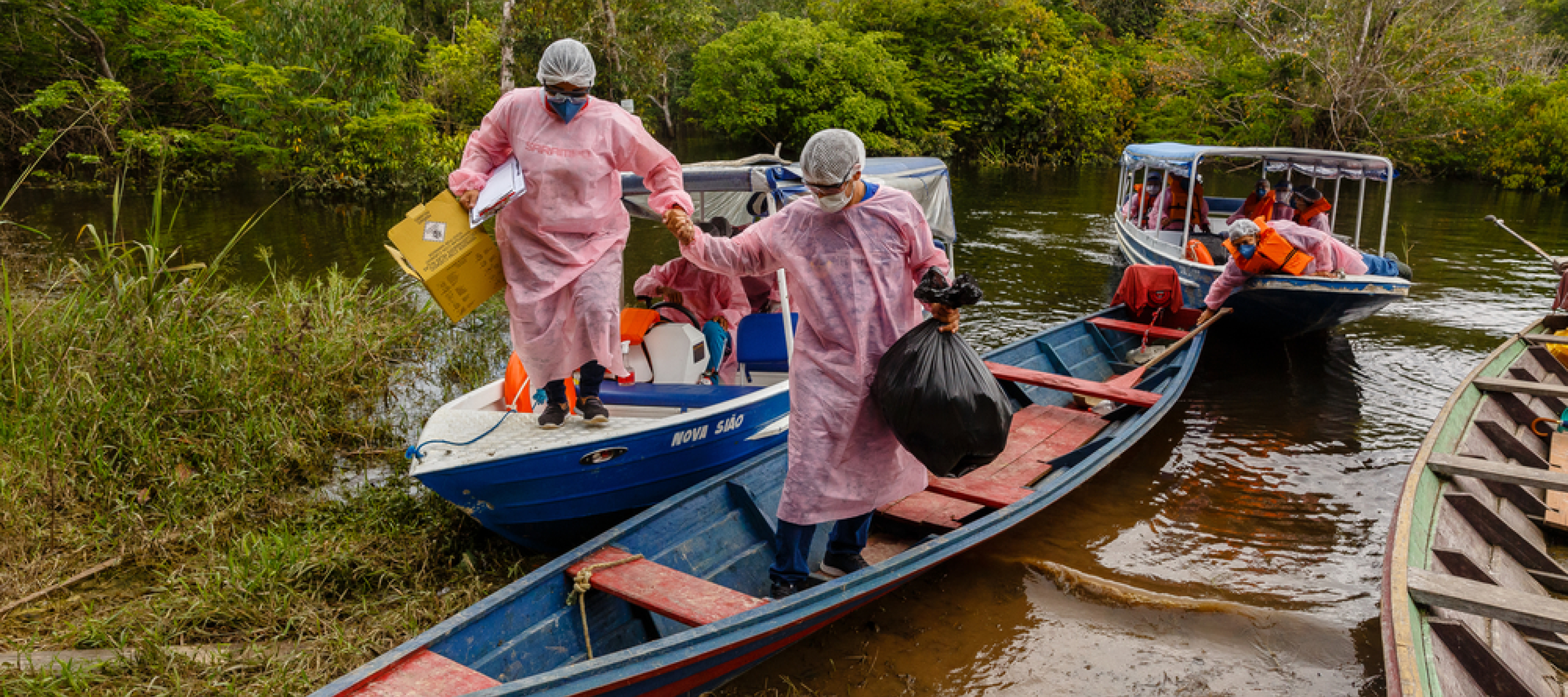 Medizinisches Personal erreicht mit kleinen Booten Ufer des Mirini See in Brasilien, um dort Menschen zu untersuchen