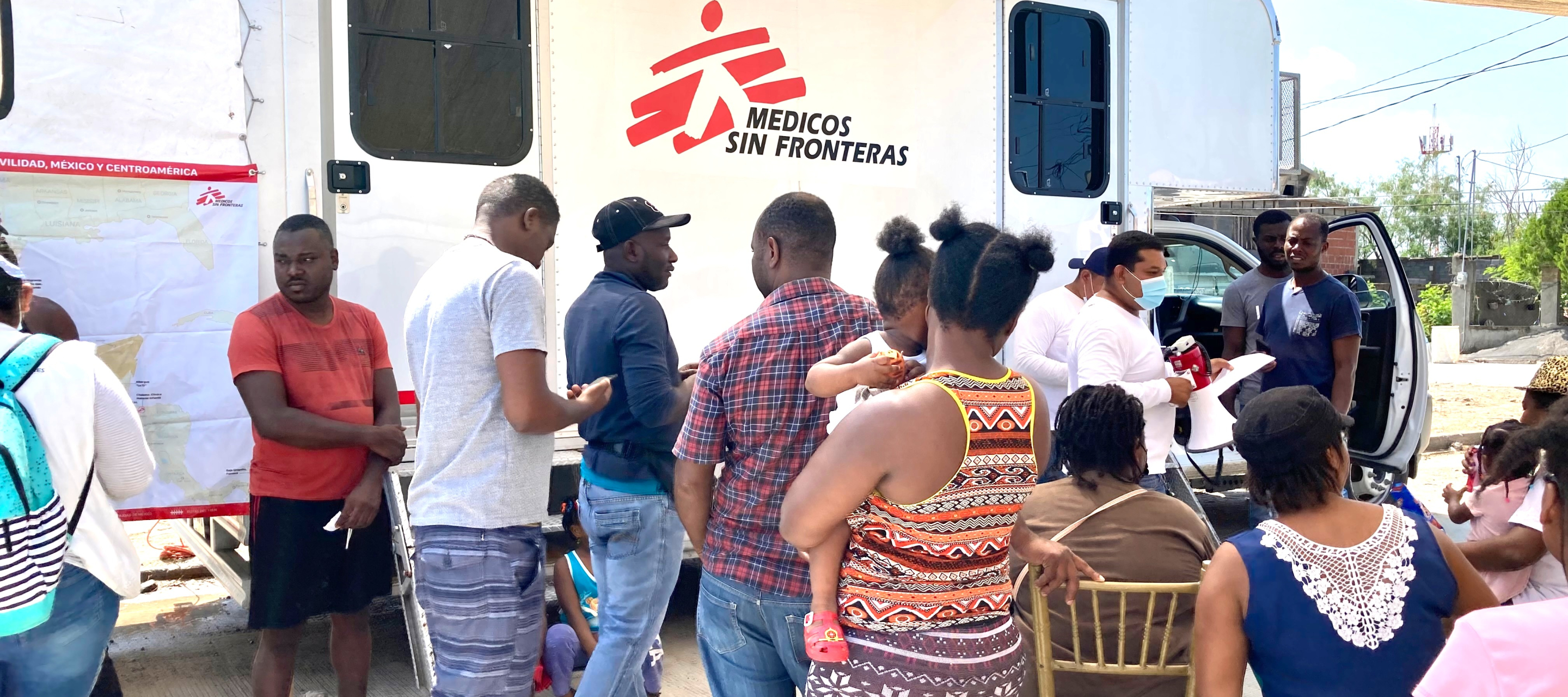 Migranten warten vor einer mobilen Klinik