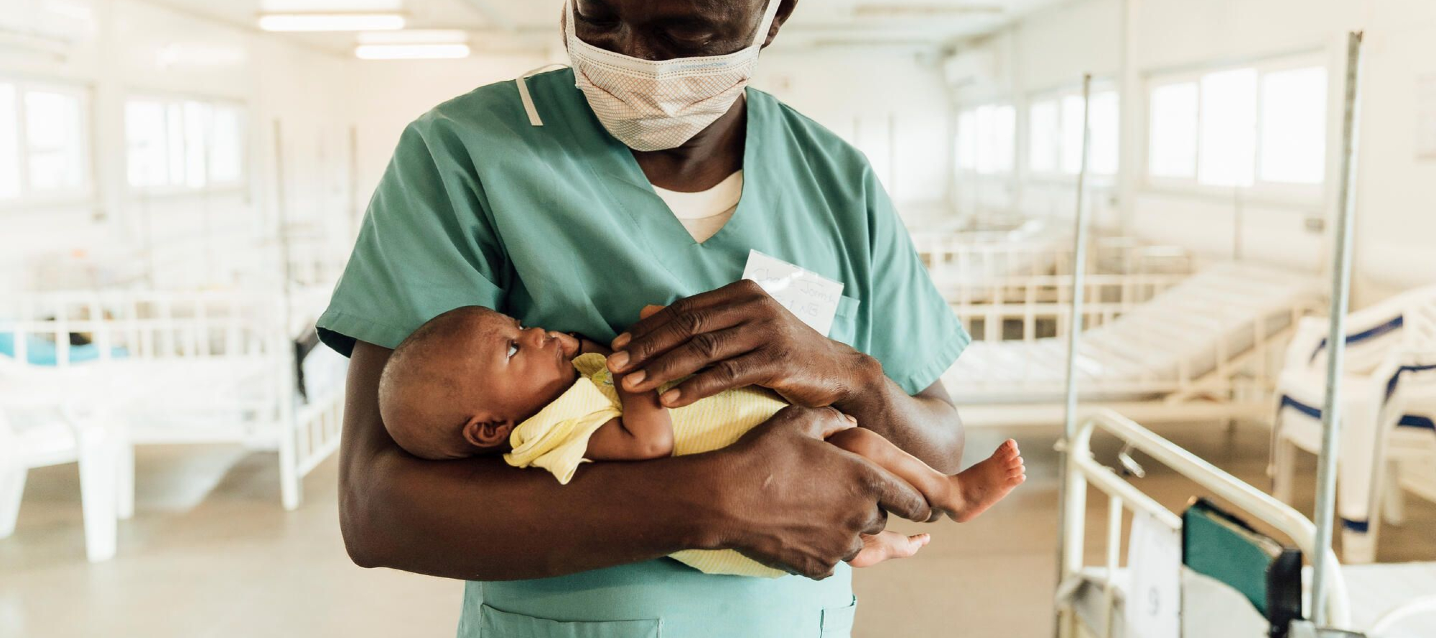 Ein Arzt hält ein Baby in den Armen