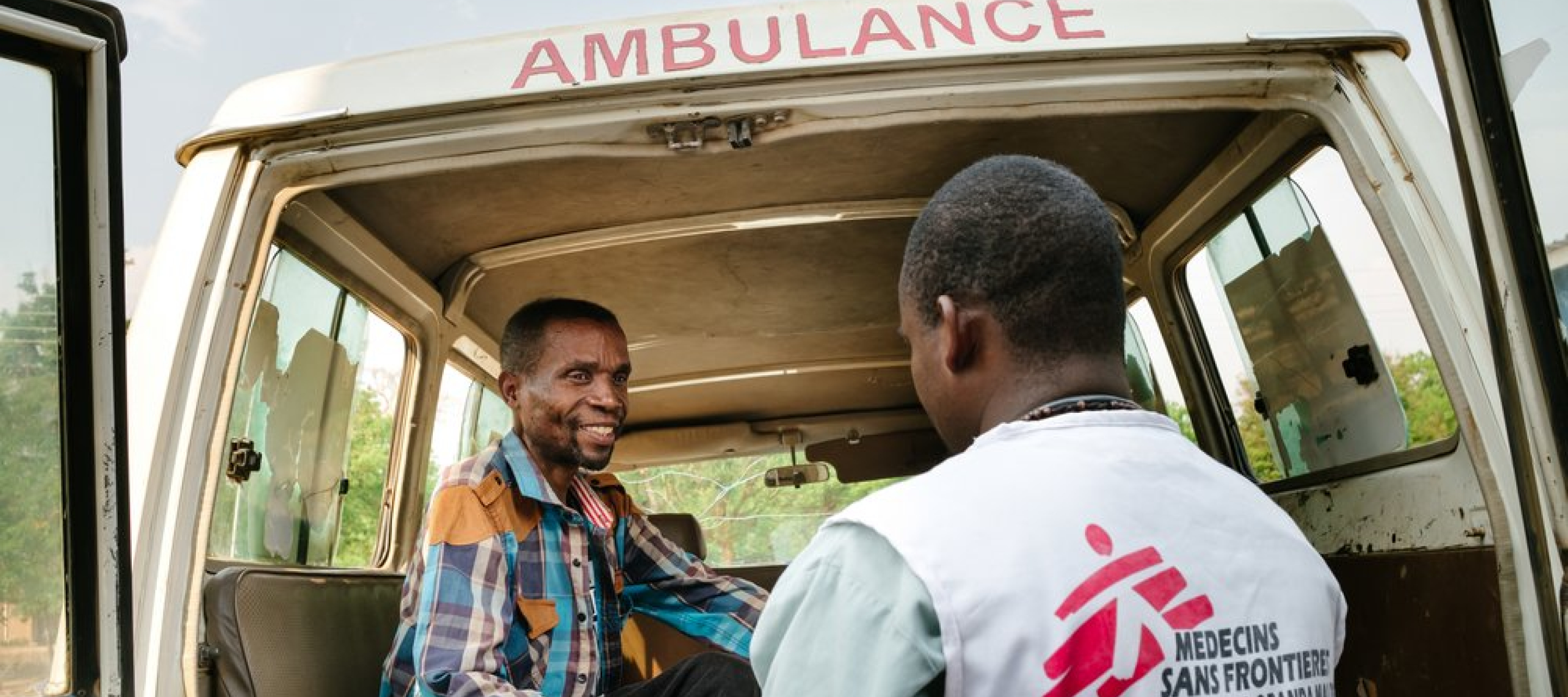 Ein Mitarbeiter hilft einem Patienten an Bord eines Krankenwagens