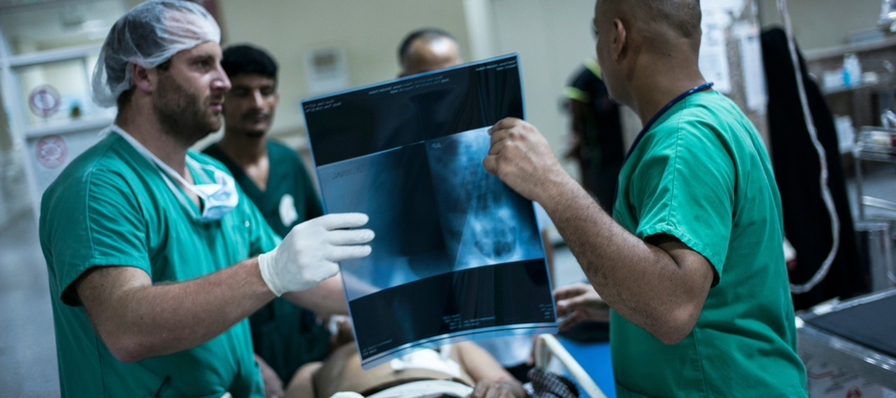 Chirurgen besprechen Röntgenbild mit Patient - humanitäre Arbeit