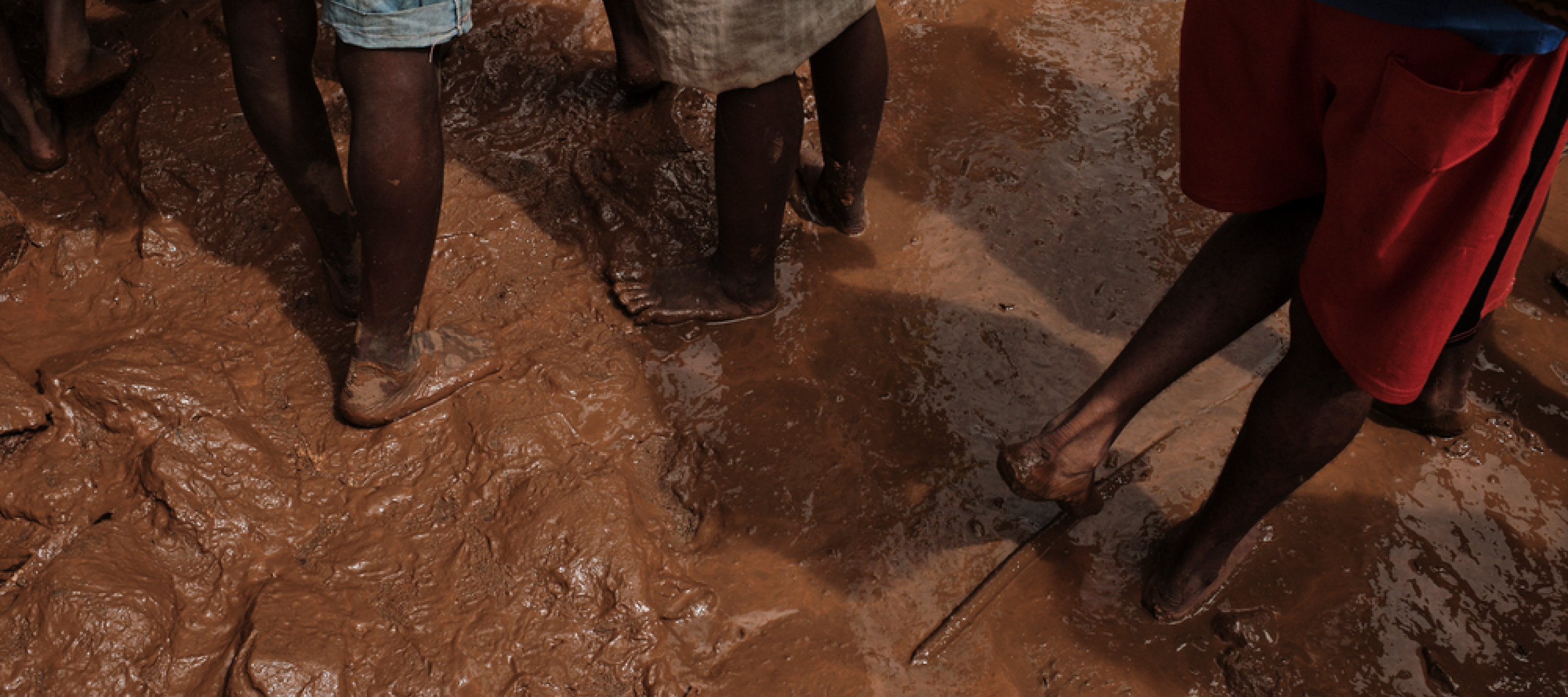 Menschen stehen mit ihren Füßem im Schlamm nach den Wirbelstürmen im Osten Madagaskars