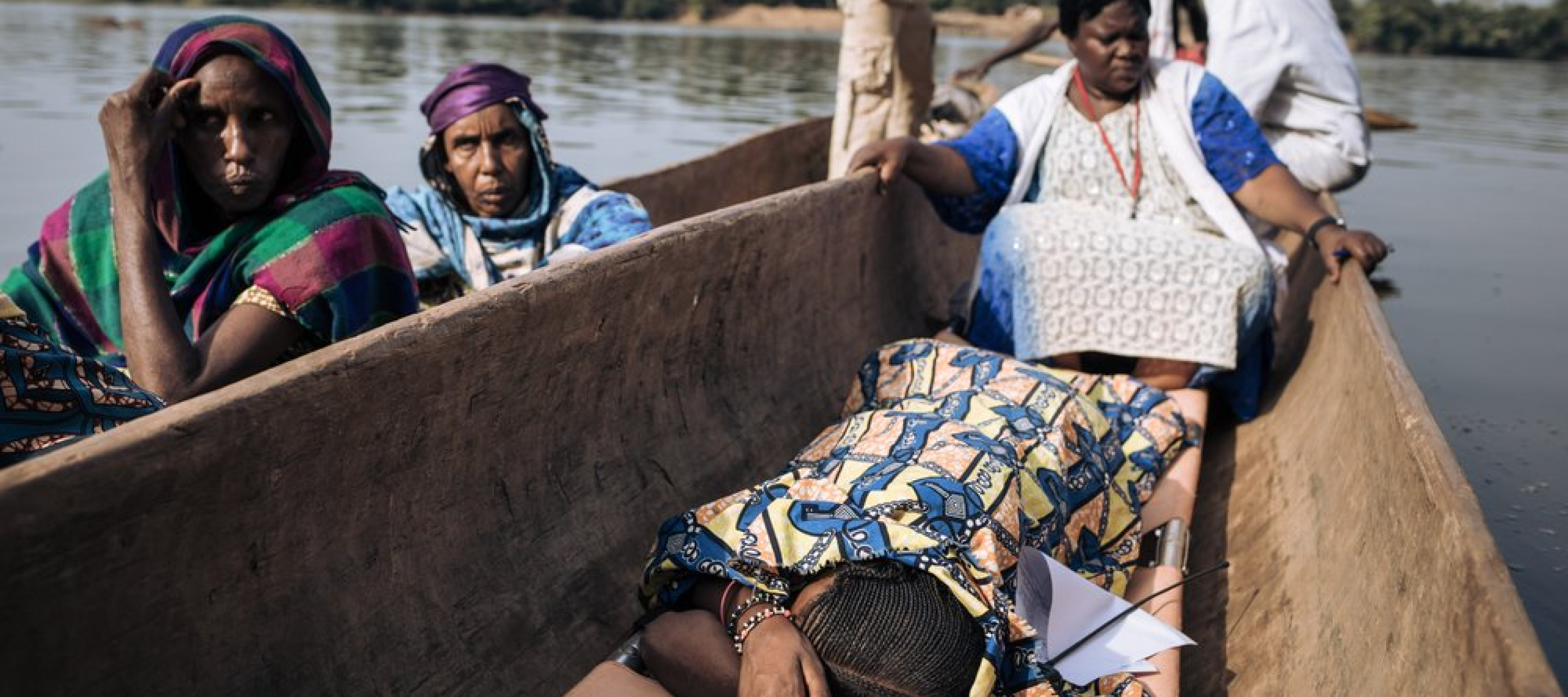 Viele Menschen aus Bangassou flohen über den Fluss nach Ndu in der Demokratischen Republik Kongo Mehrere Menschen in einem Kanu, eine Frau liegt auf einer Liege auf dem Boden