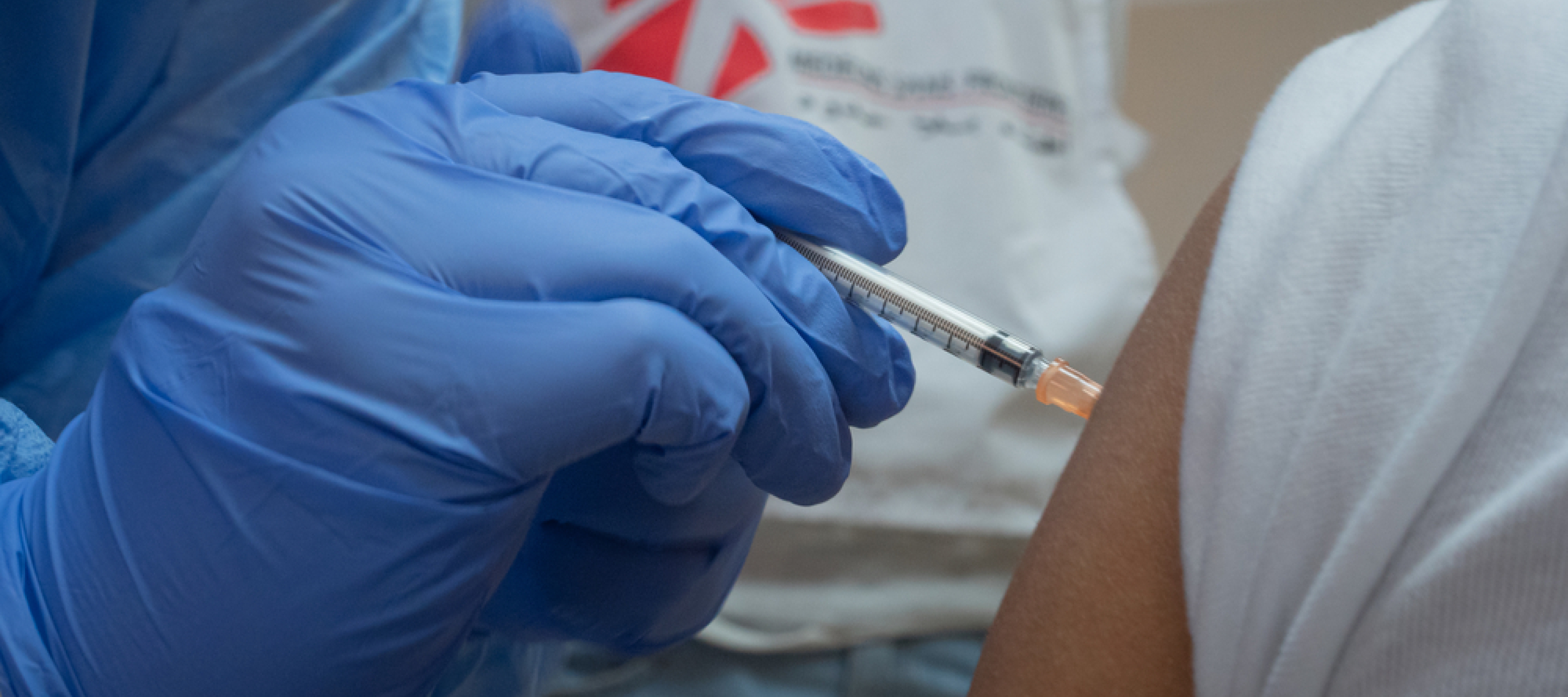 Nahaufnahme von einer Hand, die eine Covid-19 Impfung spritzt
