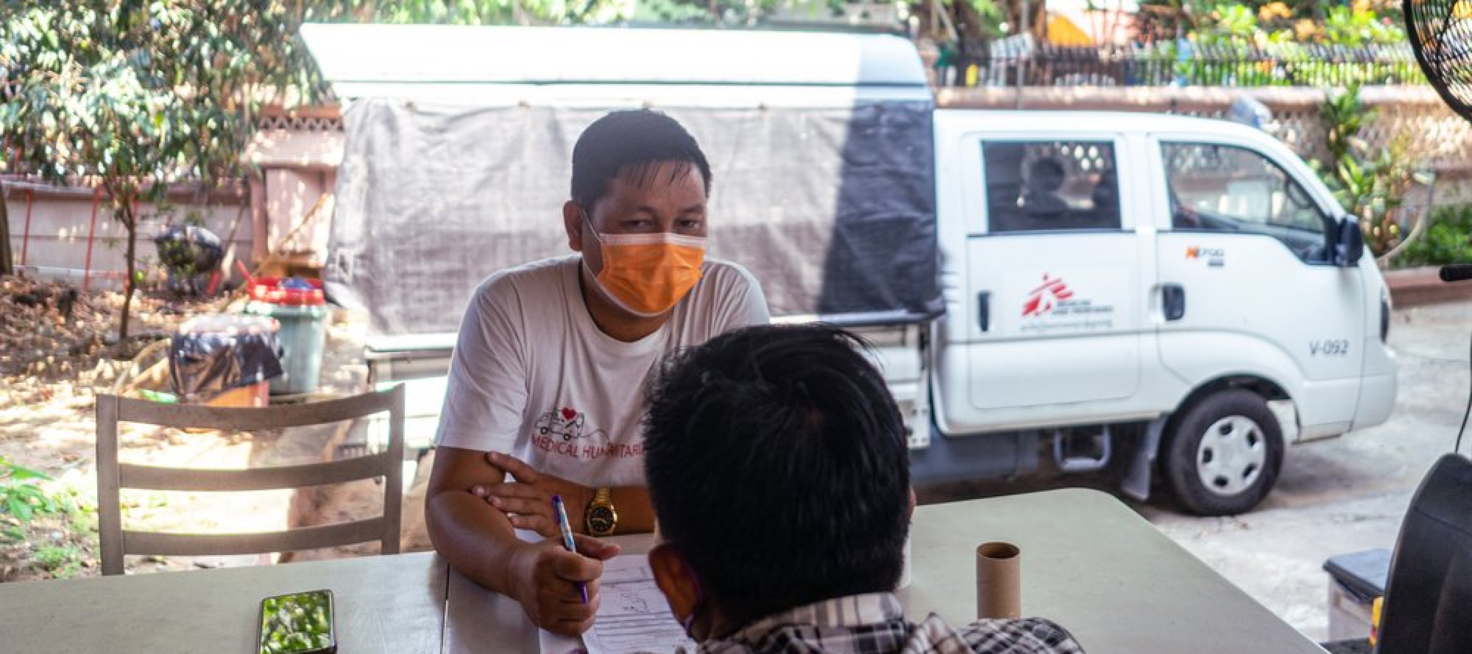 Unser Mitarbeiter führt ein Gespräch mit eine*r Patient*in. Hilfe gegen HIV und Hepatitis Myanmar
