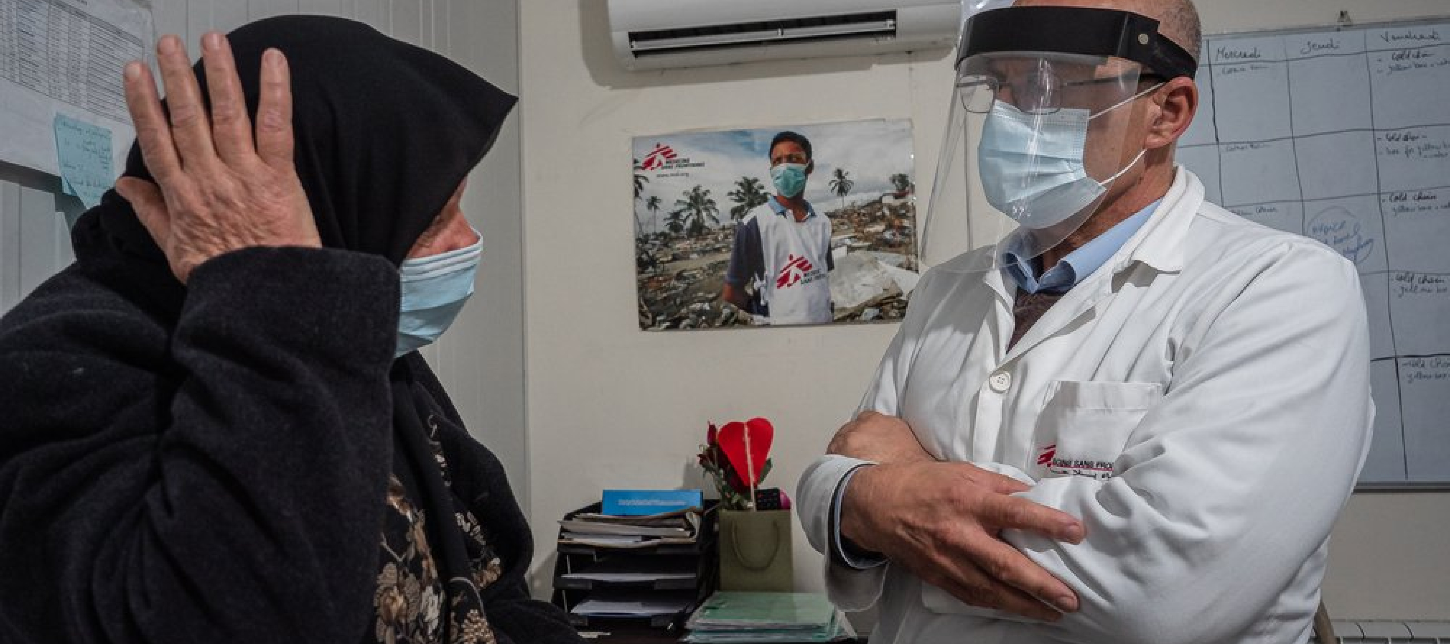 Eine Frau auf einer Krankenliege redet mit einem Arzt von Ärzte ohne Grenzen