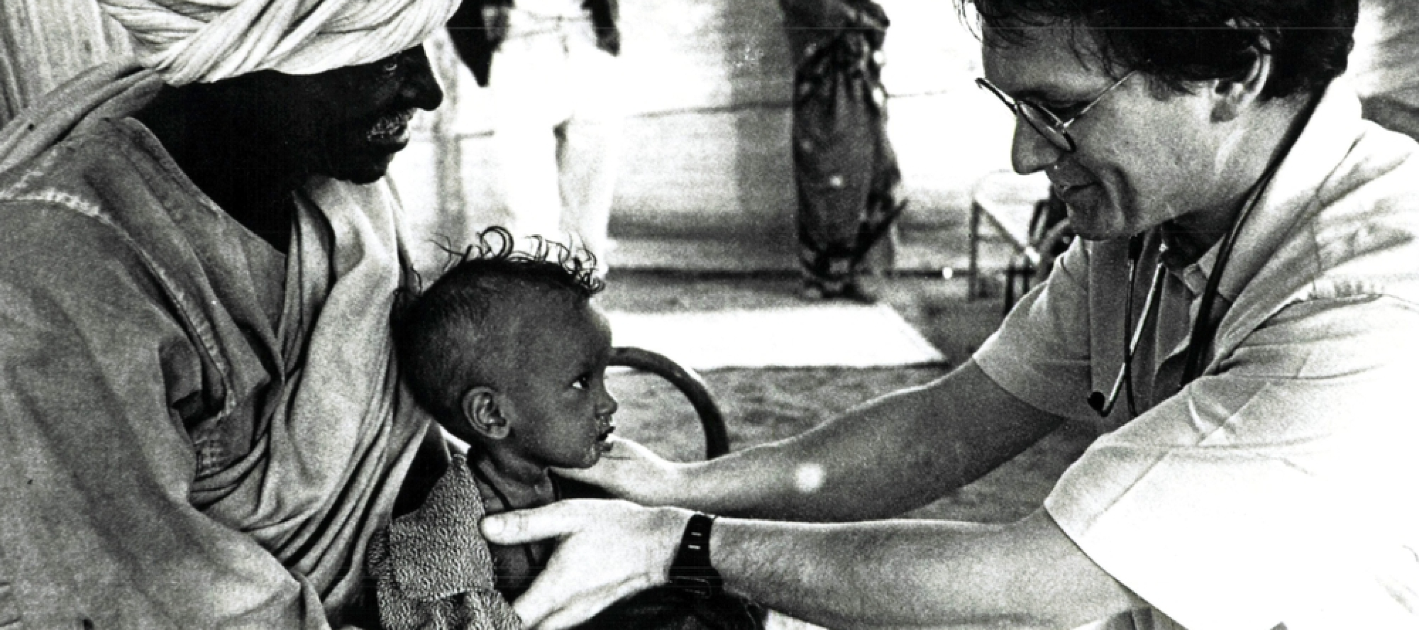 Schwarz-weiß-Foto von Arzt der Kind behandelt