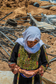 Eine ältere Frau blickt vor Trümmern in Palästina auf ihre Handinnenseite.