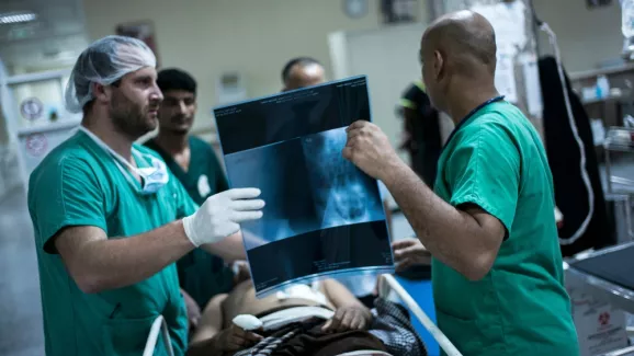 Chirurgen besprechen Röntgenbild mit Patient - humanitäre Arbeit