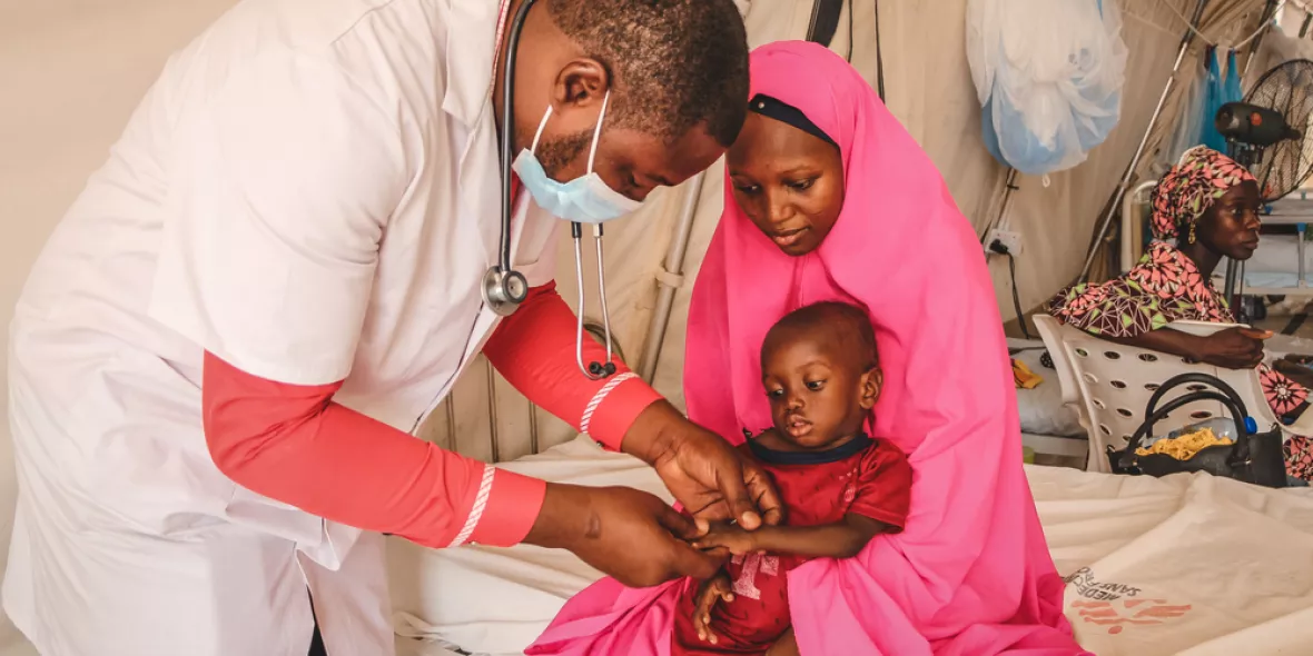 Ja'afar Ahmed ist mangelernährt und wird im Arm seiner Mutter von einem Arzt behandelt