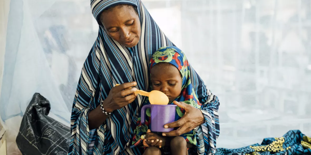 Eine Mutter füttert ihre 2-jährige Tochter auf der Mangelernährungsstation in einem Krankenhaus in Niger
