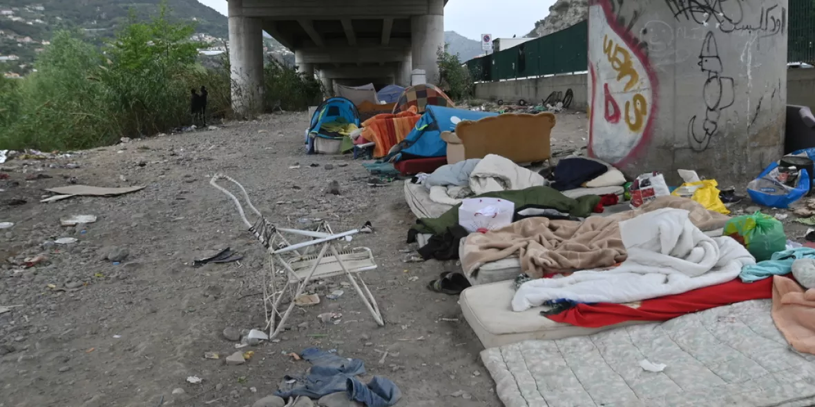 Provisorische Unterkunft aus Betten und Zelten unter einer Brücke