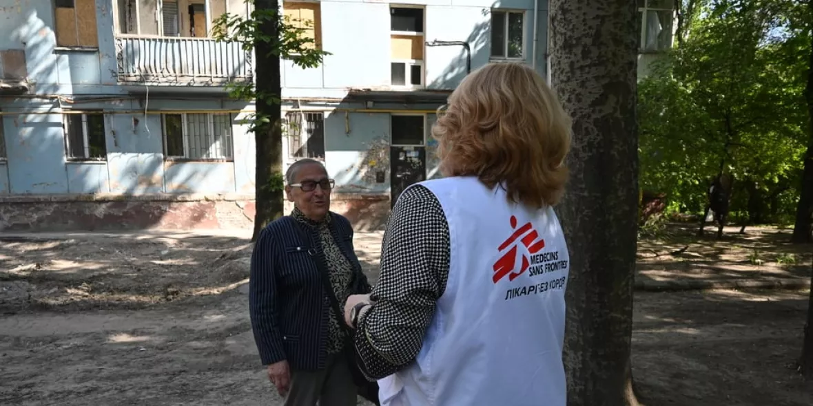 Eine unserer Mitarbeitenden spricht mit einer älteren Frau